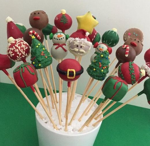 a cup filled with christmas cake pops on top of a green table