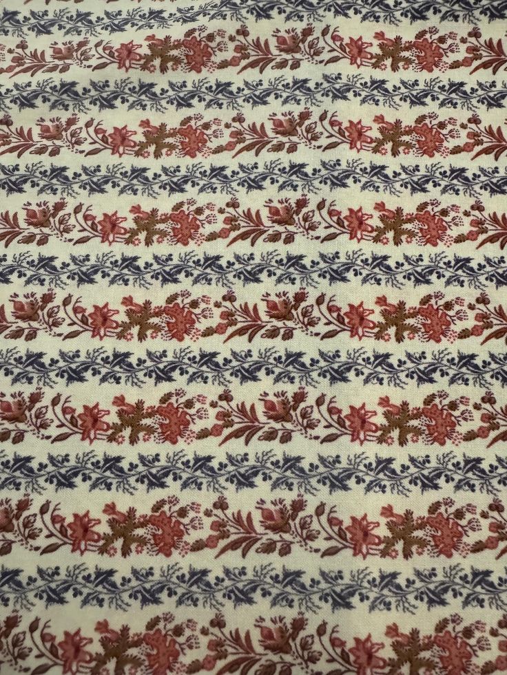 a red, white and blue fabric with flowers on it