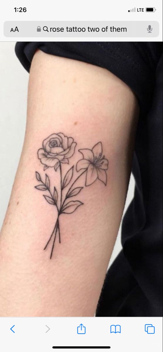 a small tattoo with flowers on the side of the arm and behind it is an arrow