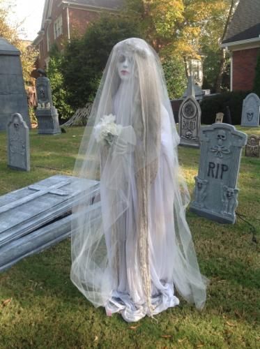 a ghostly bride in her wedding dress at the cemetery