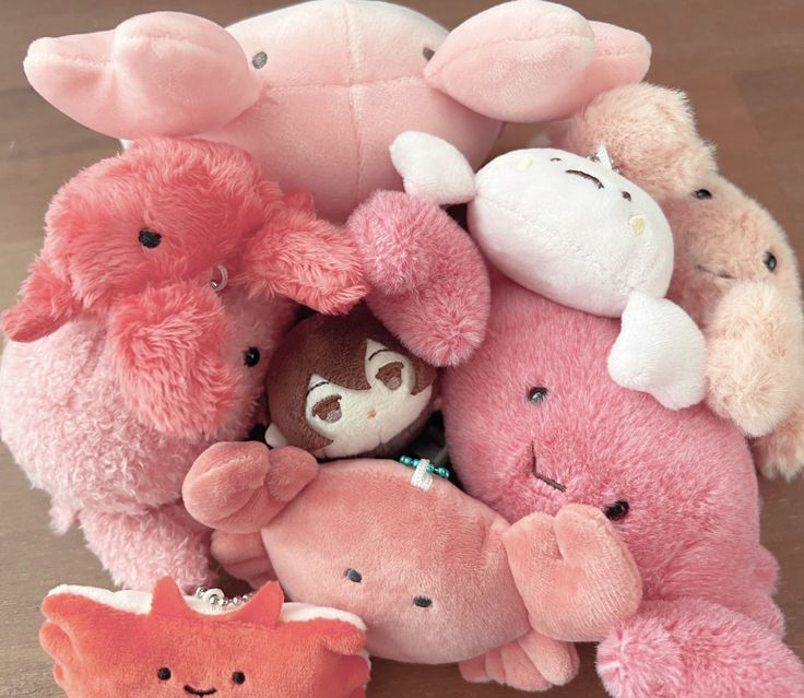 a pile of stuffed animals sitting on top of a wooden floor