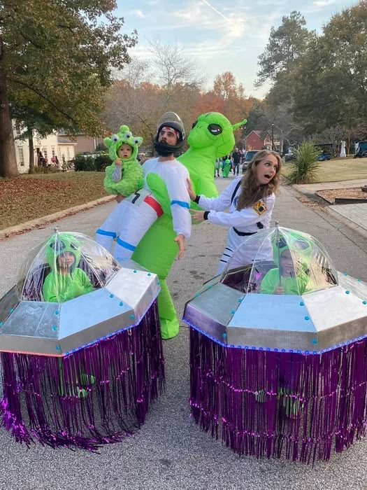 three people in costume are dancing on the street