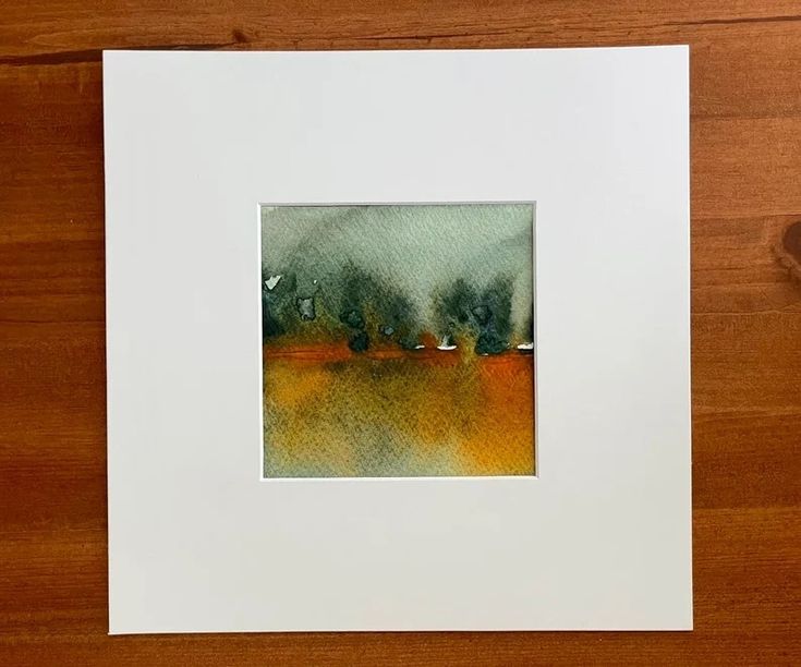 a watercolor painting of trees on a wooden table with a white frame and brown floor