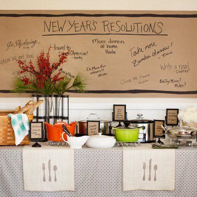 a table topped with lots of cups and saucers next to a wall covered in writing