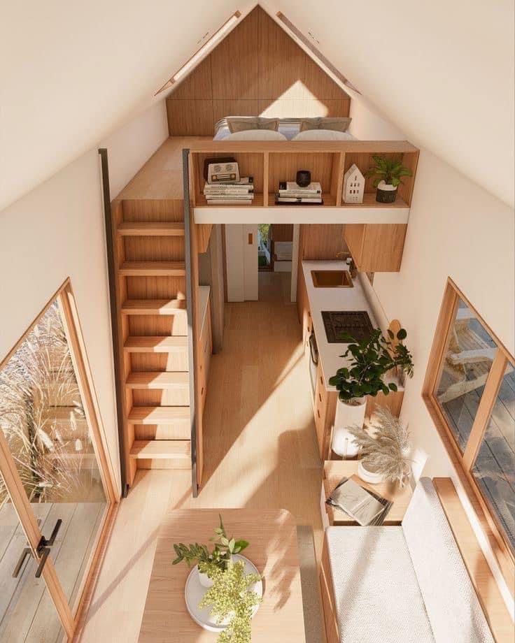 an aerial view of a living room and kitchen area in a tiny house with stairs leading up to the second floor