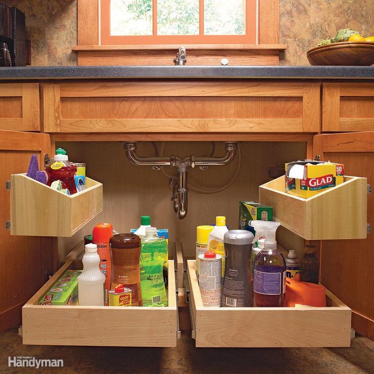 two pull out drawers in the middle of a kitchen cabinet with soaps and lotions