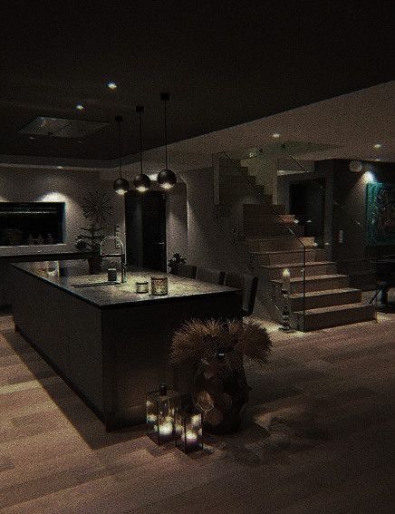 a kitchen and living room are lit up at night, with candles on the floor