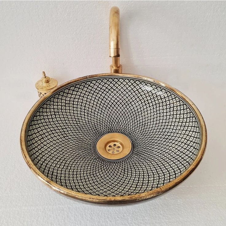 a gold plate with a button on it hanging from the wall next to a white wall