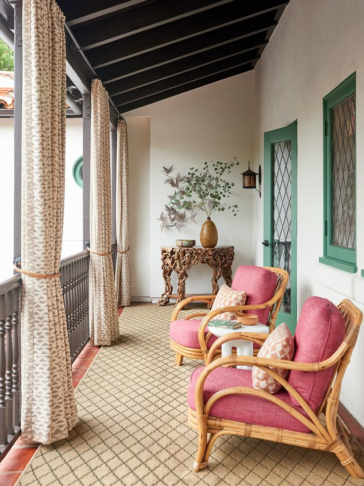 two wicker chairs sitting on top of a wooden floor next to a green door