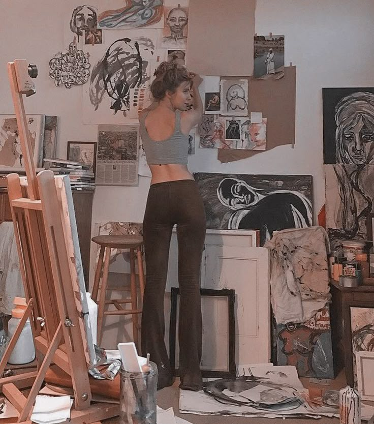 a woman is standing in an art studio