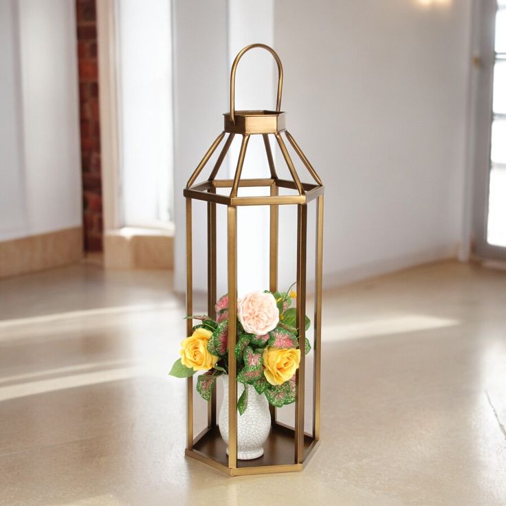 a vase filled with flowers sitting on top of a wooden table next to a candle holder