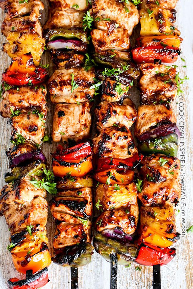 grilled chicken and vegetable kabobs on skewers with garnishes