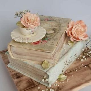 a cake made to look like an old book with flowers on top