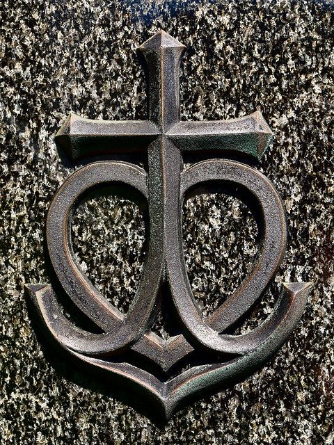 an old metal cross on the side of a building