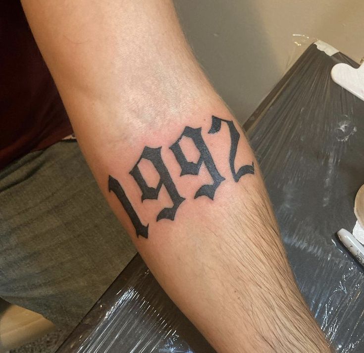 a man with a tattoo on his arm that says 2097 in cursive letters