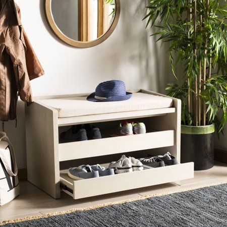 a white bench with shoes on it in front of a mirror and potted plant