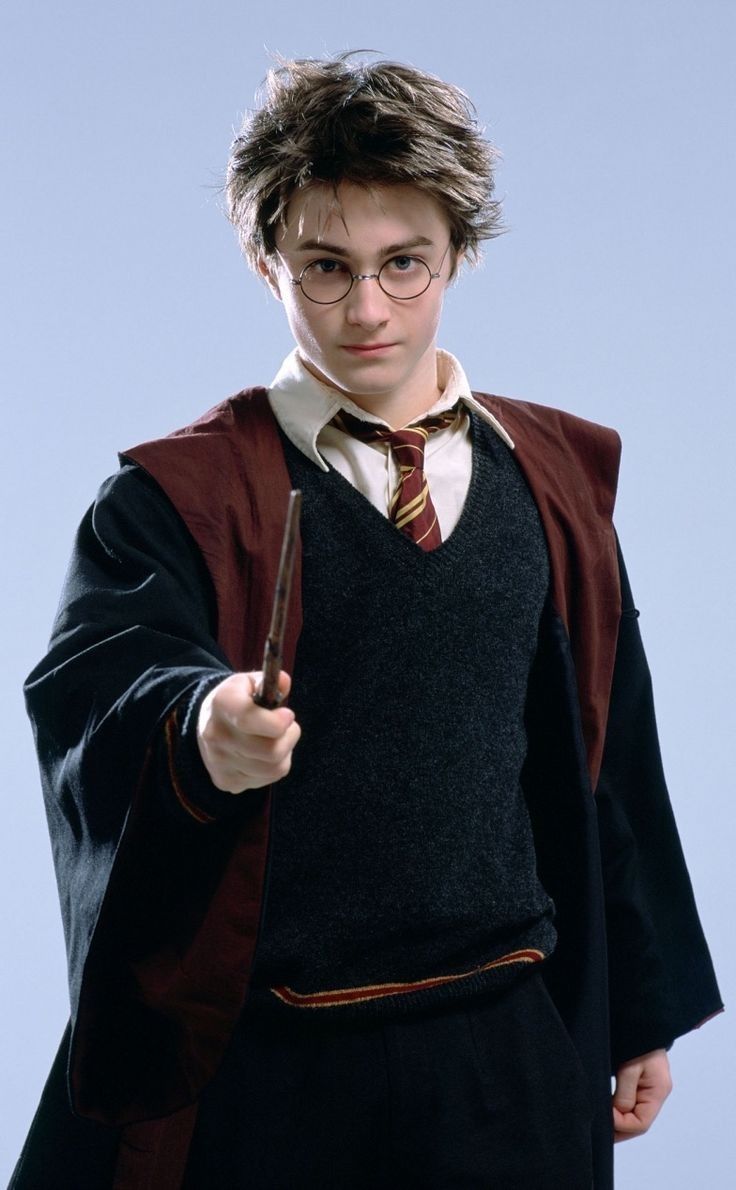 a young man dressed as harry potter holding a wand