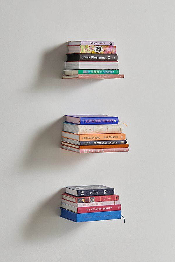 three books are stacked on top of each other in the shape of an arrow,