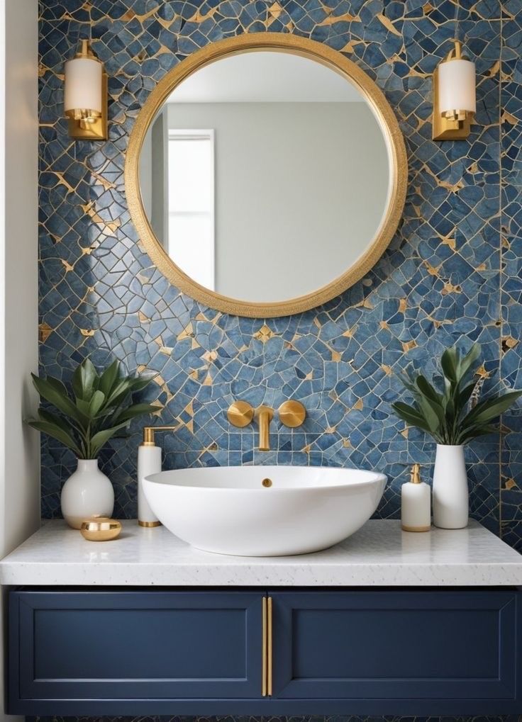 a bathroom with blue and gold tiles on the wall, a round mirror above the sink