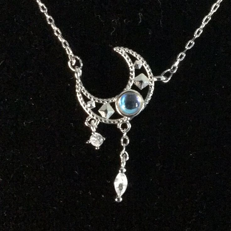 a silver necklace with a blue stone on the bottom and a chain attached to it