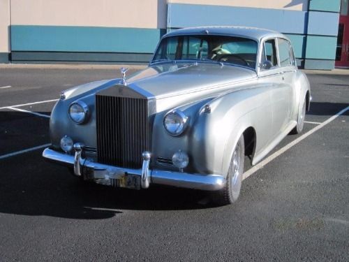 an old car parked in a parking lot with the words gulliwing motor cars