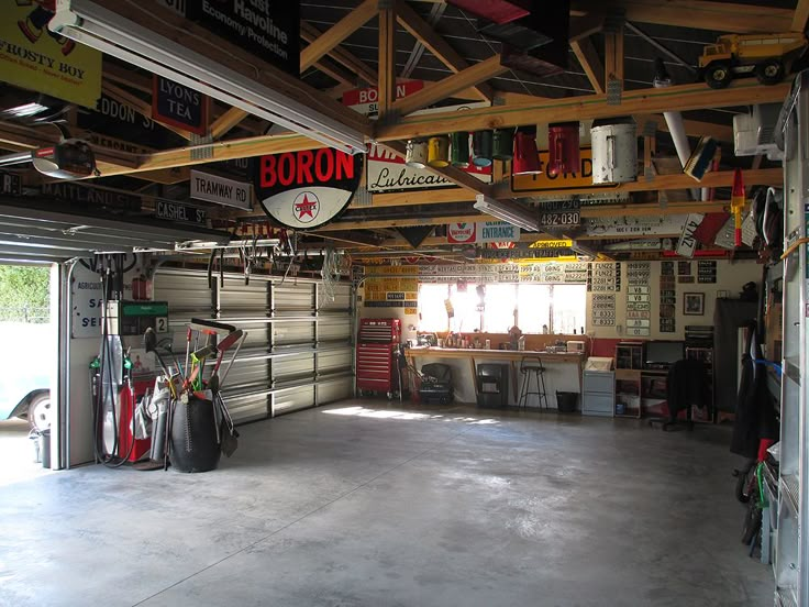 the inside of a garage with various signs and tools hanging from the ceiling, including an open door