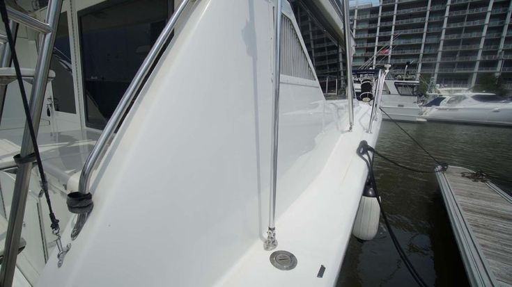 the front end of a white boat docked at a dock