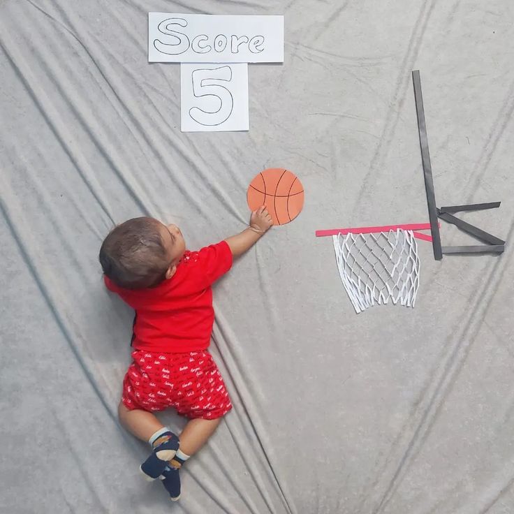 a small child is playing with some basketballs