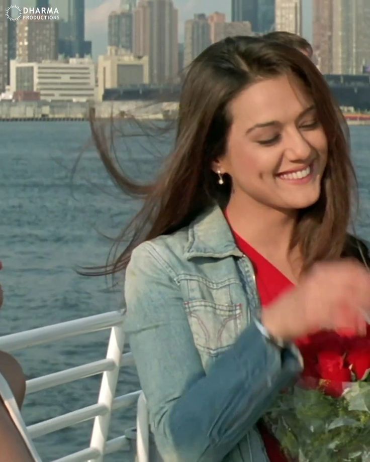 a woman is smiling and holding flowers on a boat