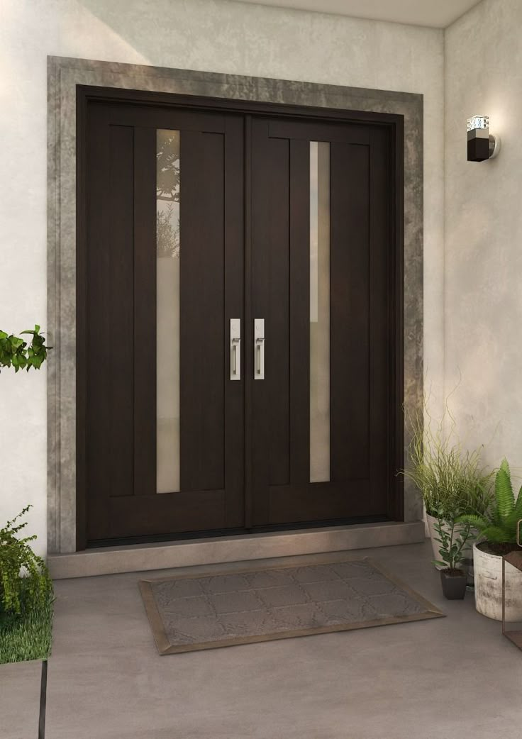 the front entrance to a house with two doors and potted plants on either side