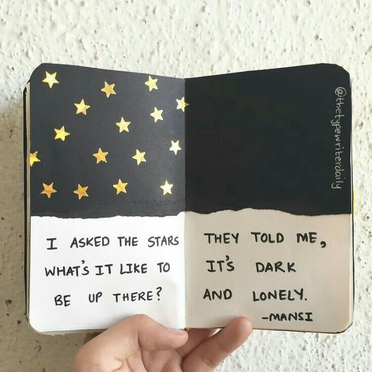 someone is holding an open book with writing on it and stars painted on the pages