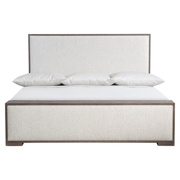 a bed with white linens and pillows on it's headboard, in front of a white background