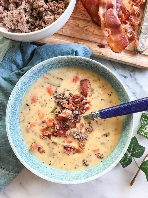 a bowl of soup with meat and cheese in it next to other food items on a cutting board