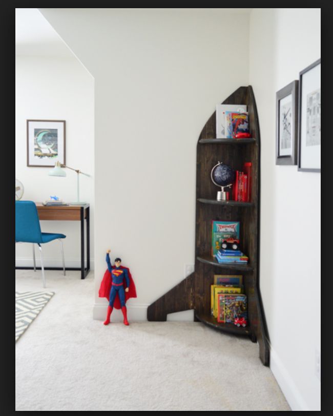 a room with a book shelf and superman figure