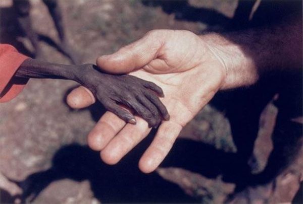 black and white photograph of two hands reaching out to touch each other's hand