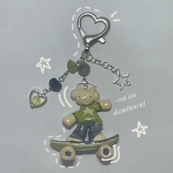 a key chain with a teddy bear on a skateboard