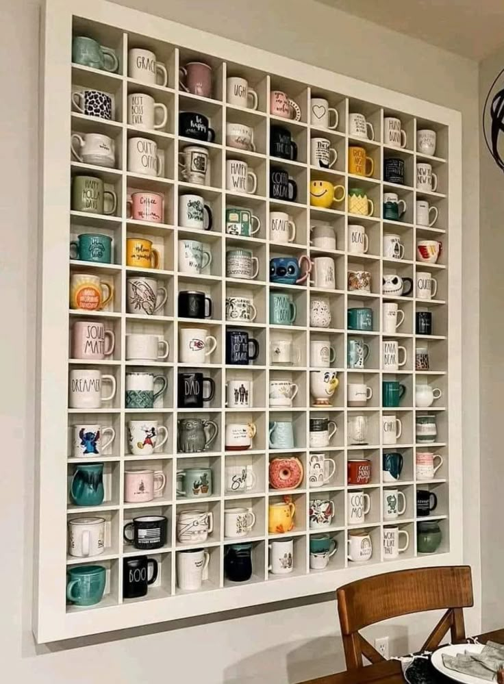 a table with plates and cups on it in front of a wall mounted coffee mugs