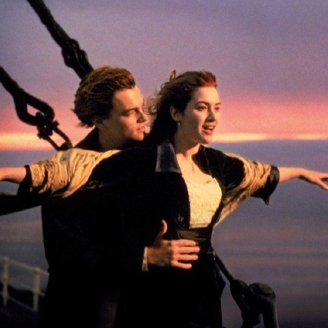 a man and woman standing next to each other on top of a boat in the ocean