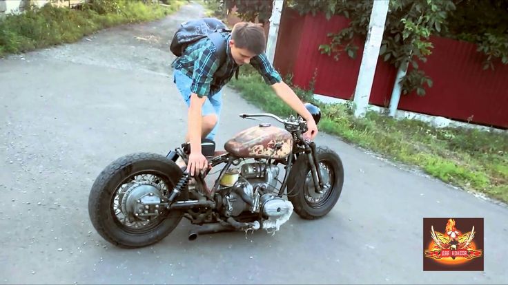 a man is bending over to look at his motorcycle