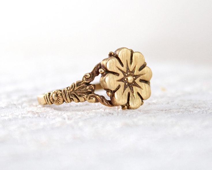 A timeless flower ring modeled after an authentic Victorian antique. Made to order and handmade in Colorado.  DETAILS: Band is 1.75mm wide by 1mm thick Daisy top is 11mm in diameter Solid 14k yellow, white or rose gold Handmade in Colorado Made to order - Please allow 2-3 weeks for production Modeled after an authentic Victorian ring, this flower ring design is just as relevant now as it was over one hundred years ago. The ornately-carved details hug close to your finger. The low profile design Heirloom Style Flower Ring For Promise With Intricate Design, Heirloom Gold Ring With Antique Finish, Heirloom Style Gold Ring With Antique Finish, Vintage Gold Flower Promise Ring, Heirloom Rings With Antique Finish For Anniversary, Heirloom Gold Flower Ring, Vintage Style Gold Flower Promise Ring, Gold Vintage Style Flower Promise Ring, Antique Finish Rings For Anniversary