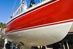 a red and white boat sitting on top of a dock next to people standing near it