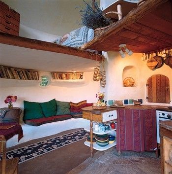 a living room filled with lots of furniture next to a stove top oven and microwave