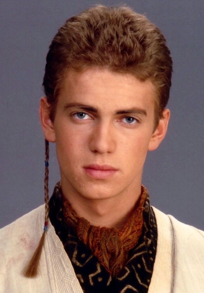 a young man with braids on his hair wearing a white jacket and black shirt