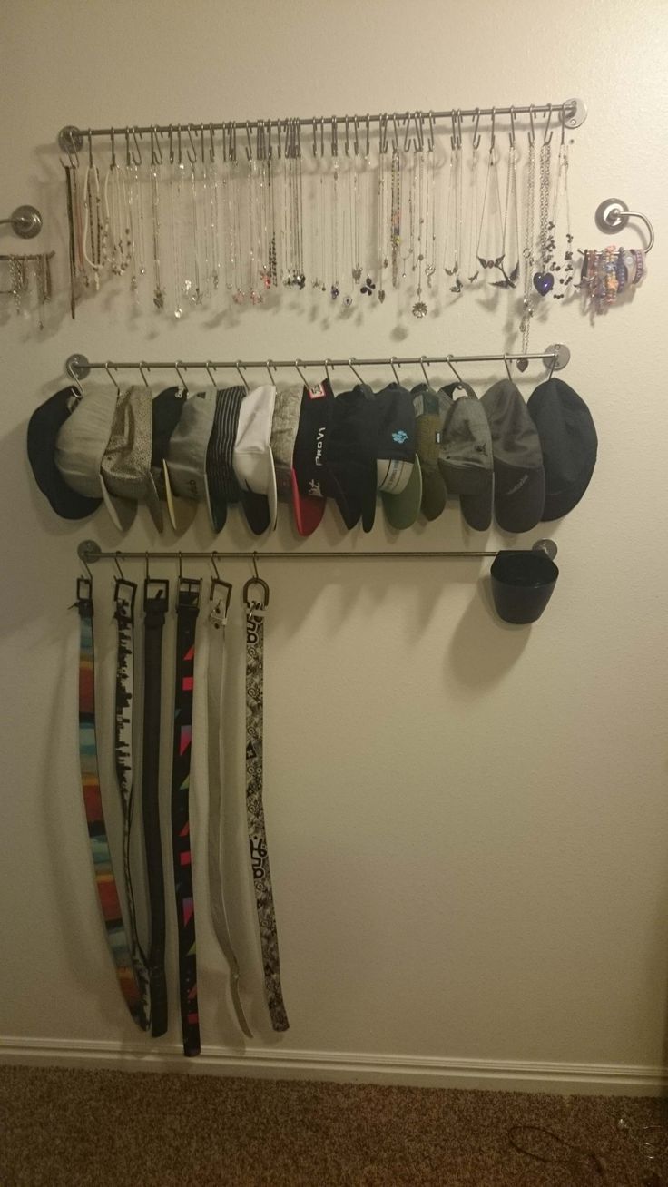 a rack with hats and ties hanging from it's sides next to a wall