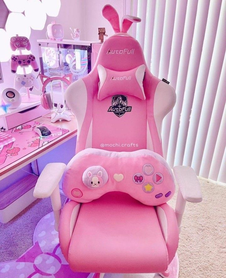 a pink gaming chair sitting on top of a carpet next to a desk and mirror