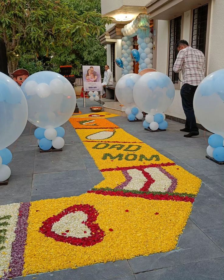 balloons and streamers are on the sidewalk for an outdoor event that is decorated with flowers