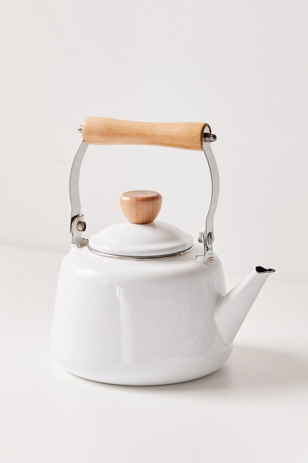 a white tea kettle with a wooden handle