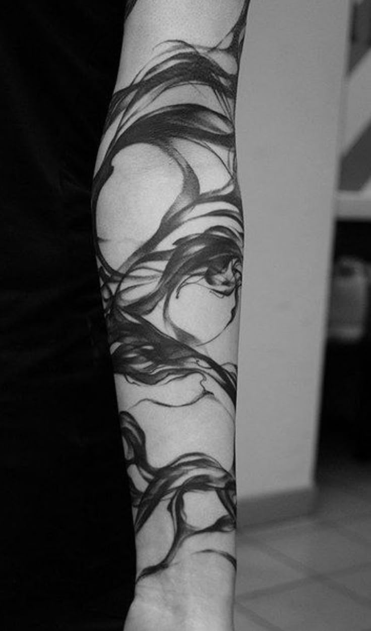 a woman's arm with black and white ink on the left side of her arm