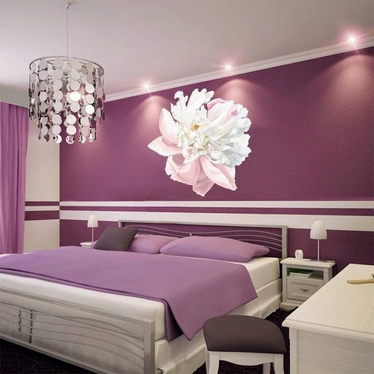 a bedroom with purple and white walls, a chandelier hanging from the ceiling