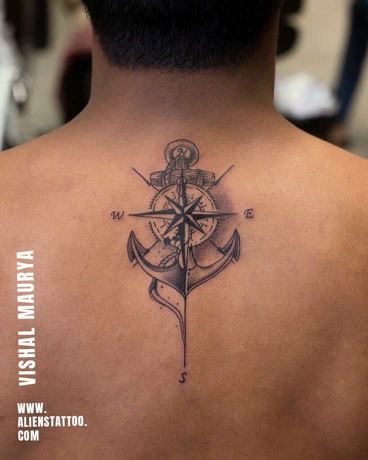 a man with a compass tattoo on his back